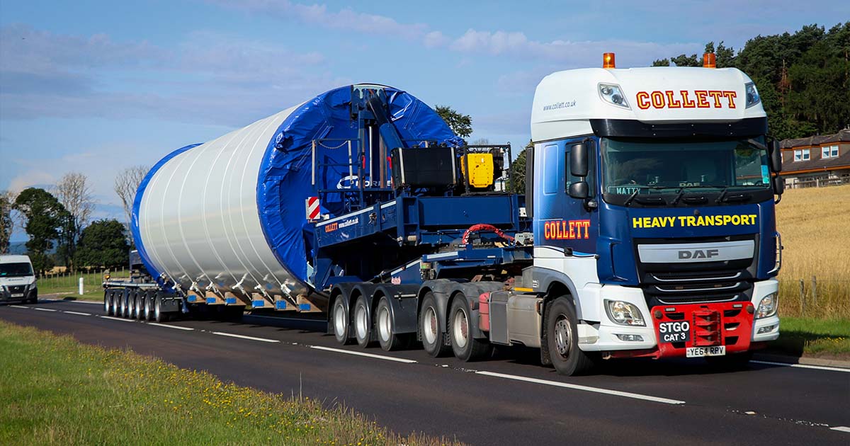 Wind turbine tower section transported by Collett using a tower clamp trailer